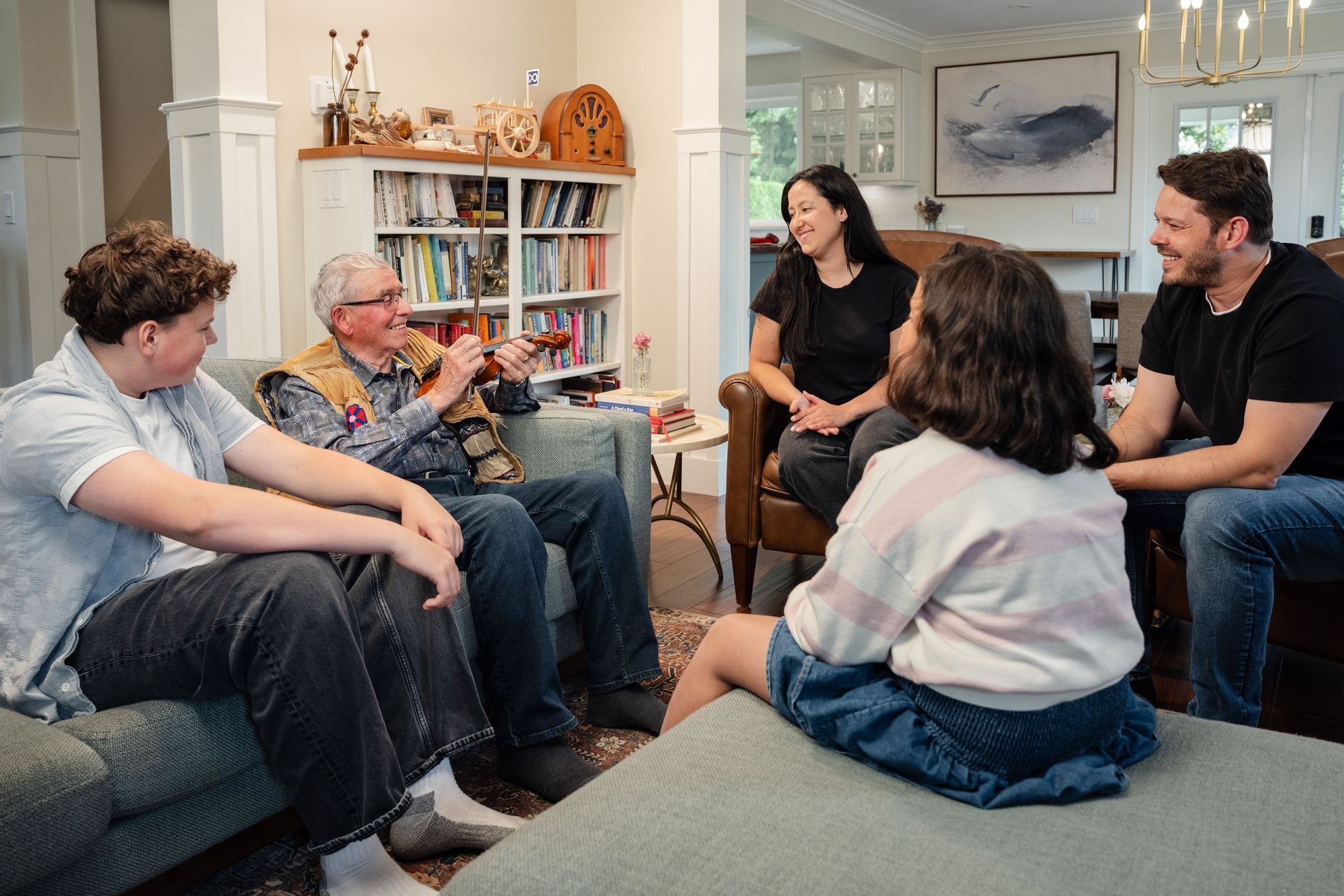 A multigenerational family engages in a lively conversation in a cozy living room setting.