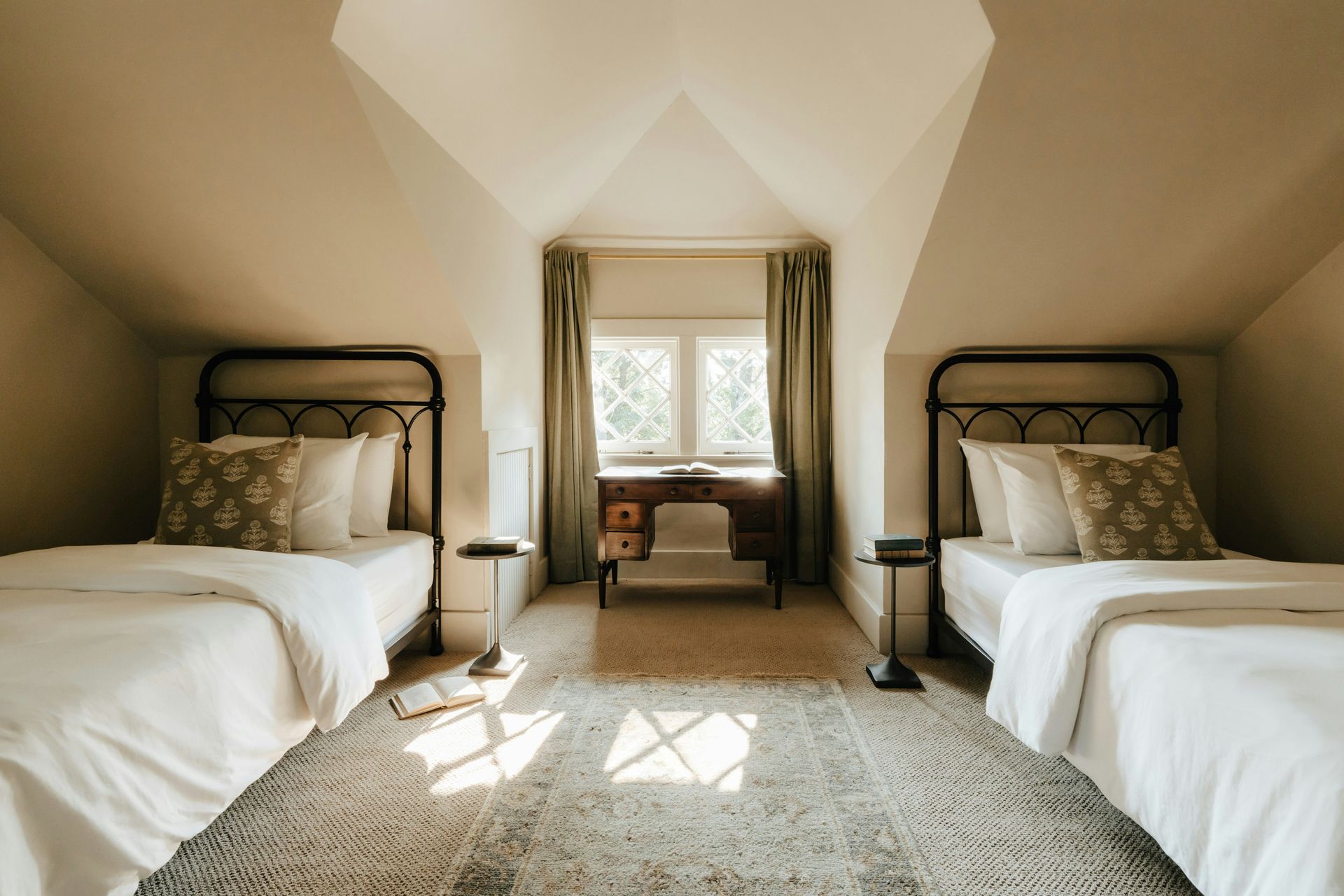 A room with two beds and a rug on the floor